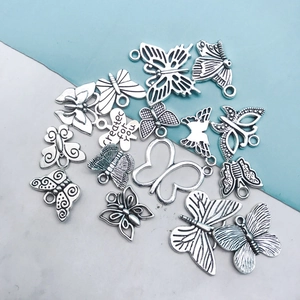 Detailed view of assorted silver butterfly charms with 'created for you' engraving