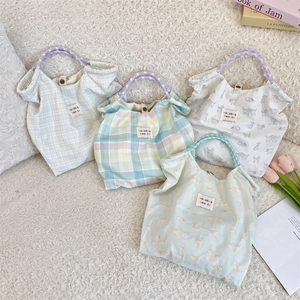 Detailed overhead view of four floral and plaid canvas tote bags with woven rope handles