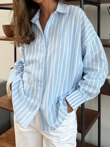 Vue détaillée de la chemise à rayures verticales bleu clair avec col polo et boutons