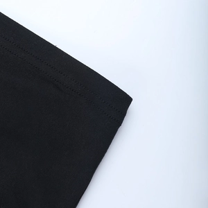 Vue détaillée d'une robe en maille noire avec ourlet à double couture et texture de tissu fin