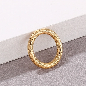 Detail showing vintage gold quilted grid pattern and glossy finish on stainless steel ring