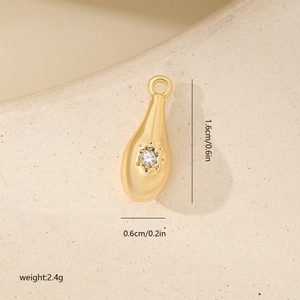 Macro shot of gold teardrop pendant with zircon, 1.6cm x 0.6cm dimensions and weight detail
