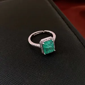 Luxury vintage adjustable ring with rectangular green emerald stone and zircon pavé halo
