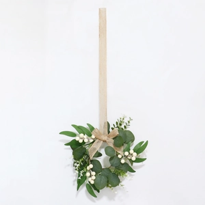 Detail of artificial eucalyptus wreath with white berries and rustic linen bow hanger