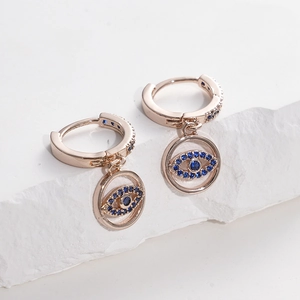 Detail of rose gold evil eye hoop earrings with blue cubic zirconia on stone base