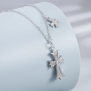 Elegant S925 sterling silver cross necklace with pavé zircons on a blue display stand