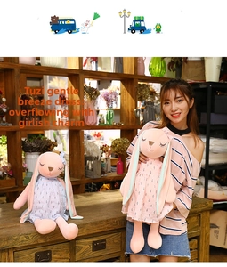 Detail of pink plush rabbits wearing light blue and pink floral dresses on a shelf