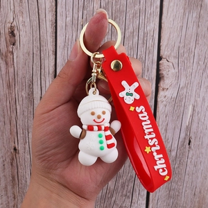 Detail of Christmas snowman keychain with a red silicone strap and a golden metal clasp