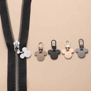 Macro shot of detachable metal Mickey-shaped zipper pullers in various metallic finishes