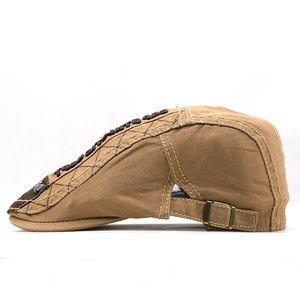 Detail of dark khaki cotton flat cap featuring contrast stitching and bronze metal buckle