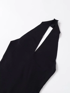 Detail shot of the neckline on a black knitted halter top with pleated fabric texture