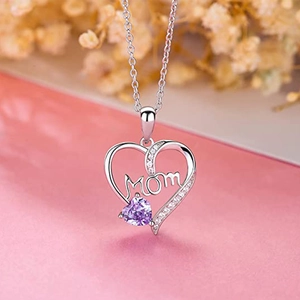 Macro shot of silver heart pendant with purple gemstone and MOM lettering on a chain