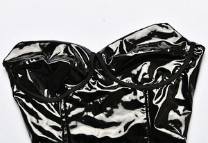 Detail of black glossy faux leather bodysuit with structured cup design and shiny finish