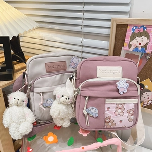 Détail de jolis sacs bandoulière en toile avec breloque ours et poche transparente