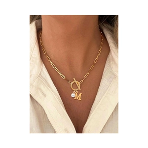 Golden OT clasp paperclip necklace with pearl and letter M pendant worn by a model