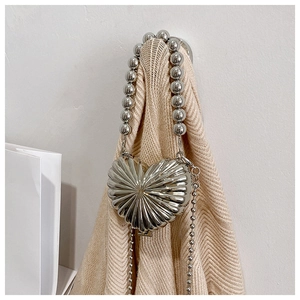 Detailed view of silver heart-shaped metal mini bag with bead handle and long chain strap