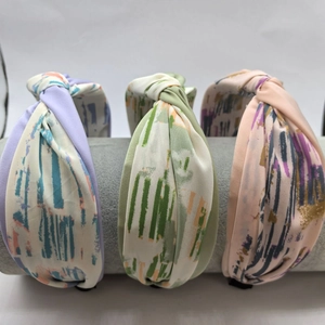 Detail view of multi-color knotted fabric headbands in elegant pastel color combinations