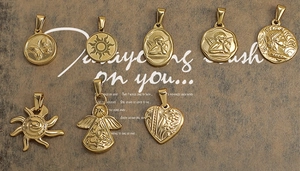 Close-up of 8 vintage gold-plated pendants featuring angels, sun motifs, and heart designs