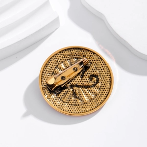 Back view of gold Eye of Horus brooch showing pin fastener and hammered metal texture