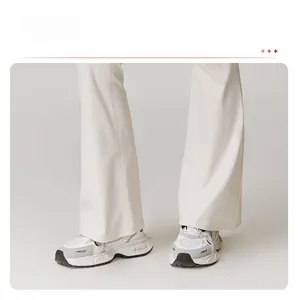 Détail du legging de yoga évasé avec ourlet élégant sur des baskets blanches
