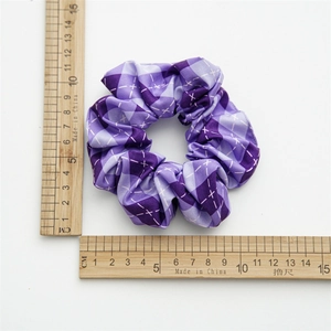 Purple plaid fabric scrunchie shown with wooden rulers for size measurement
