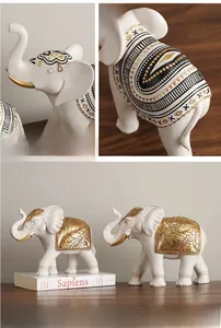 Close-up of resin elephant statues with golden relief patterns and ethnic textures