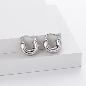 Elegant S925 sterling silver hollow hoop earrings on modern minimalist white steps