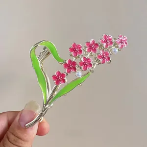 Detail of floral hair claw clip with pink enamel flowers and white pearl accents