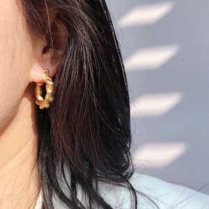 Golden 18K rope twist hoop earrings with vintage spiral texture on female model