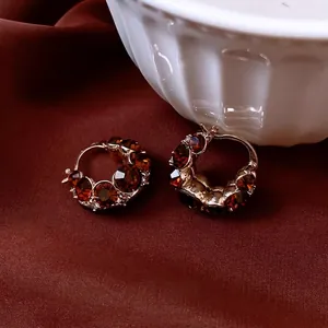 Vintage gold-plated hoop earrings with amber crystals and diamonds on red silk