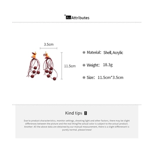 Detail view of shell and acrylic tassel earrings with dimensions 11.5cm by 3.5cm