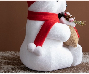 Close-up of white foam Christmas bear with red hat, scarf and burlap pine cone bag