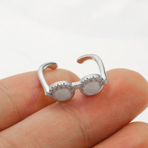 Detailed view of silver creative glasses ring with crystal accents on female finger