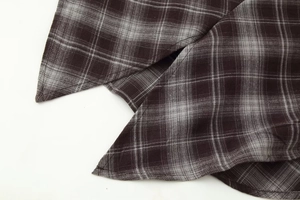 Detail shot of coffee and grey plaid fabric with fine stitching and fiber texture