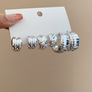 Dettaglio di un set di 6 orecchini geometrici argento con texture lisce e intrecciate