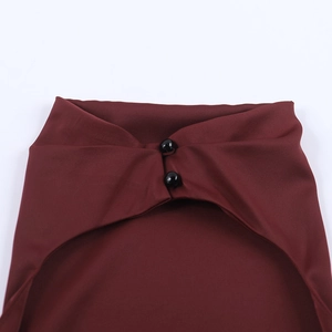 Detail of burgundy satin halter neckline with two black spherical buttons on the dress