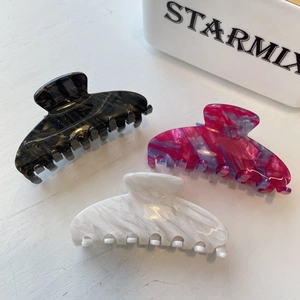 Close-up of acetic acid hair claws with black gold and white feather textures in three colors