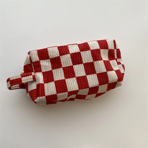 Close-up of red and white checkered velvet makeup bag with textured fabric detail