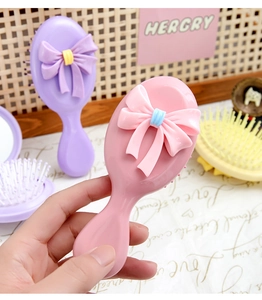Détail d'une brosse à cheveux rose avec un nœud papillon 3D mignon pour filles et femmes