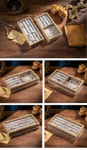 Detail of vintage acrylic jewelry box with gold patterns and grey velvet lining dividers