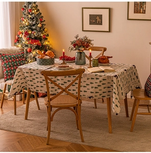 Close-up of Christmas tablecloth with green tree and deer prints on cotton-linen fabric