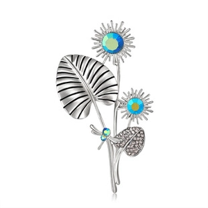 Macro shot of silver sunflower brooch featuring blue crystal centers and pavé rhinestones