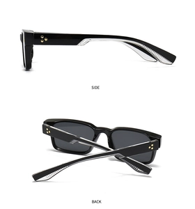 Detail view of black square sunglasses with golden triple-star rivets and grey lenses