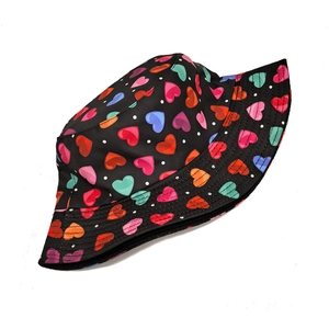 Detail of black bucket hat featuring colorful heart patterns and reinforced brim stitching