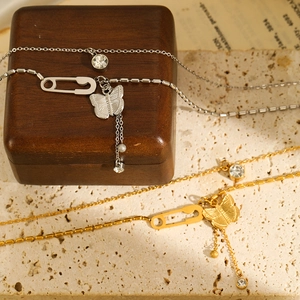 Macro shot of gold and silver butterfly necklaces with cubic zirconia charms and tassels