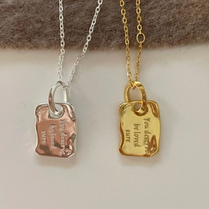 Detail of 925 silver necklaces with irregular engraved rectangular pendants