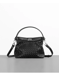 Detail of black woven leather handbag with silver metallic turn-lock and texture