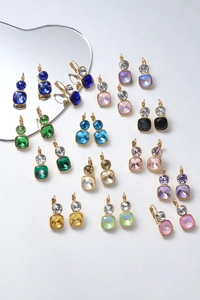 Detailed macro view of colorful crystal drop earrings with gold-plated metal settings