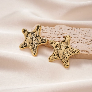 Orecchini a stella marina dorati con trama martellata su elegante pietra beige