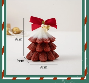 Christmas tree candle in red and white with bow and bell, measuring 9cm by 9cm